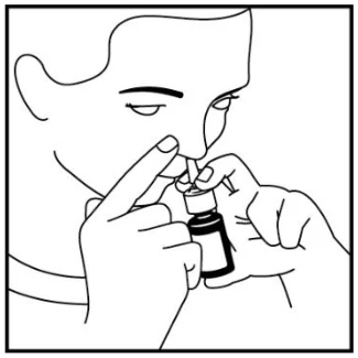 A person using a small bottle
Description automatically generated