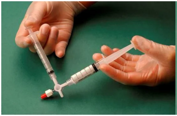 A close-up of hands holding a syringe
Description automatically generated